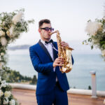 A wedding saxophonist playing in a wedding in Corfu for a couple from England-UK-Grate Britain, he is performing the saxophone on the coctail hour-welcomedrink