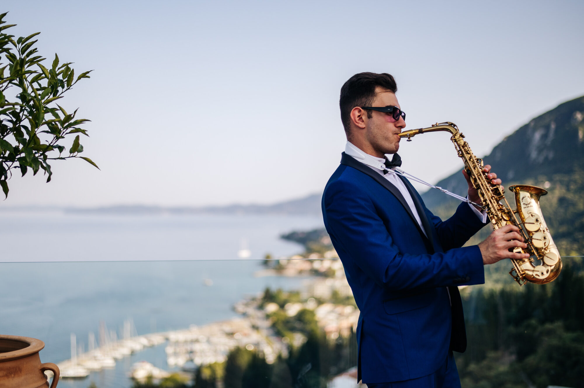 A wedding saxophonist playing in a wedding in Corfu for a couple from England-UK-Grate Britain, he is performing the saxophone on the coctail hour-welcomedrink